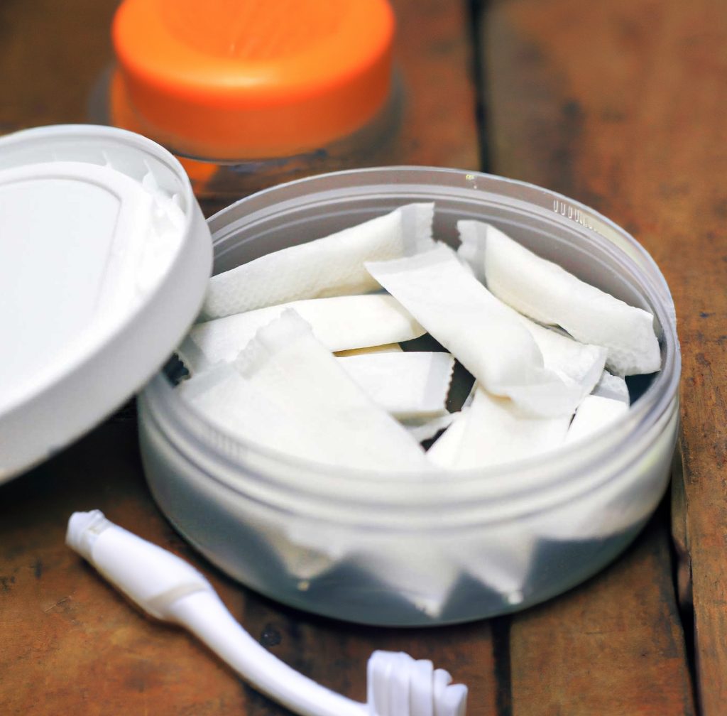 A can of tobacco-free snus with toothpaste next to it.